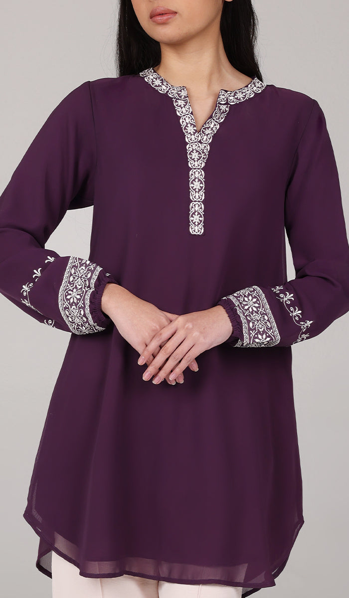 Woman wearing Amalie tunic in Eggplant. 