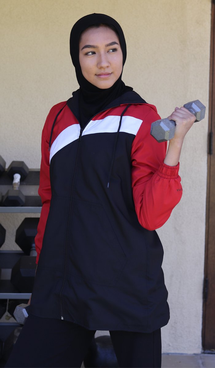 Woman wearing sports hijab in Black and lifting weights.