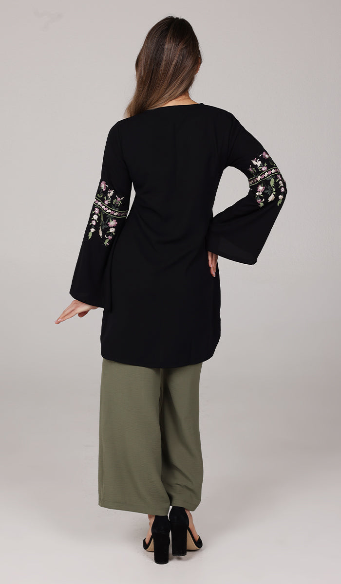 Back view of model wearing Black Gulzar tunic with Olive pants and black heels. 