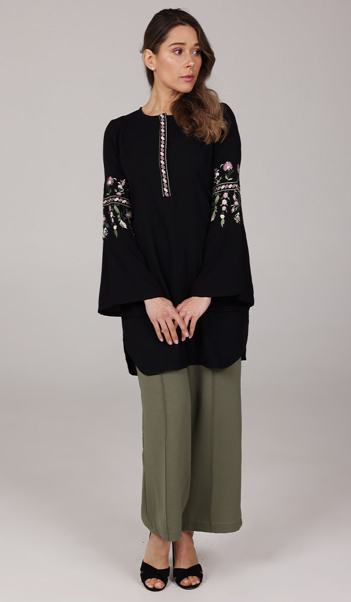 Model wearing black embroidered Gulzar tunic with olive pants and black heels. 