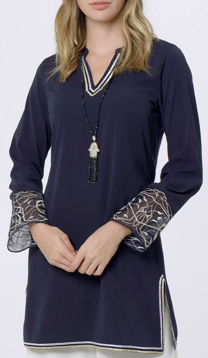 Woman wearing Ines tunic in Midnight with Khamsa necklace. 