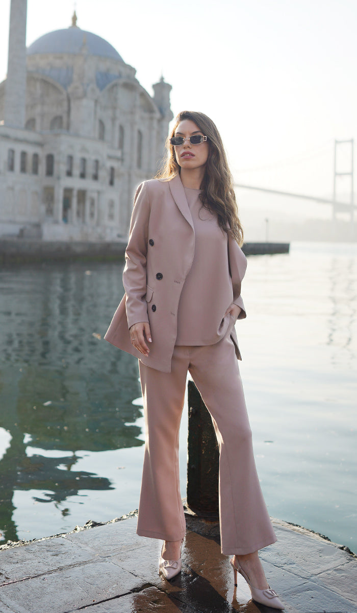 Woman wearing Lyla taupe suit set with hand in pocket.