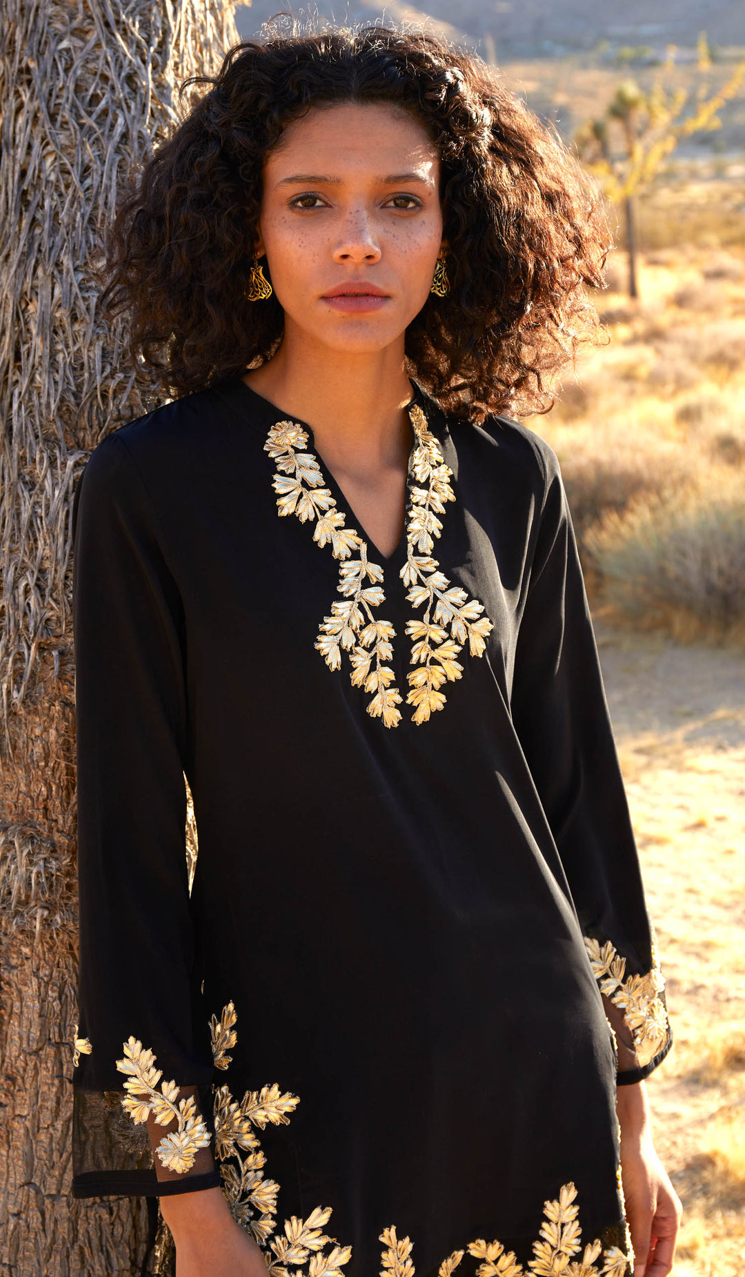 Woman by tree at sunset wearing Mahnaz Gold Embellished Long Modest Tunic in Black.