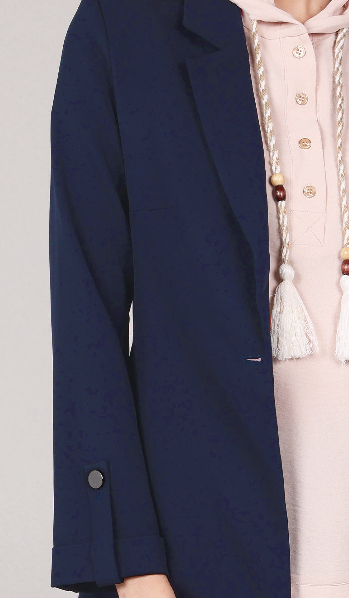 closeup detail of navy blue blazer with sleeve pull-tab.